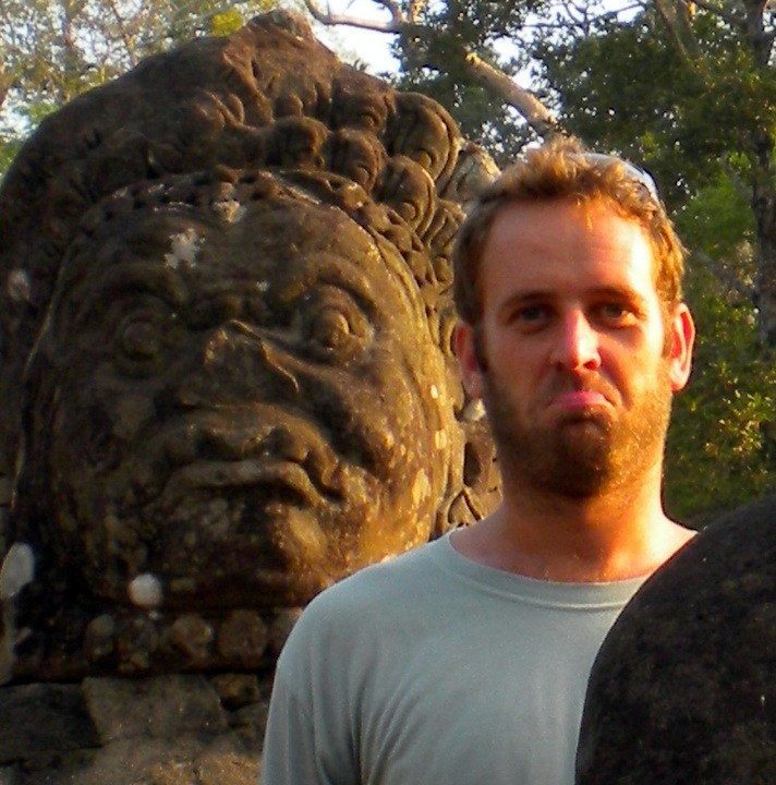 Brian posing with a statue of Angkor Wat, Cambodia