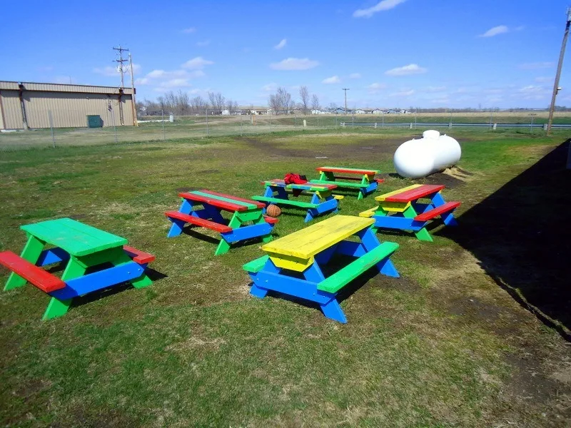 Colorful picnic tables in the back yard of the Boys and Girls Club of Three Districts.