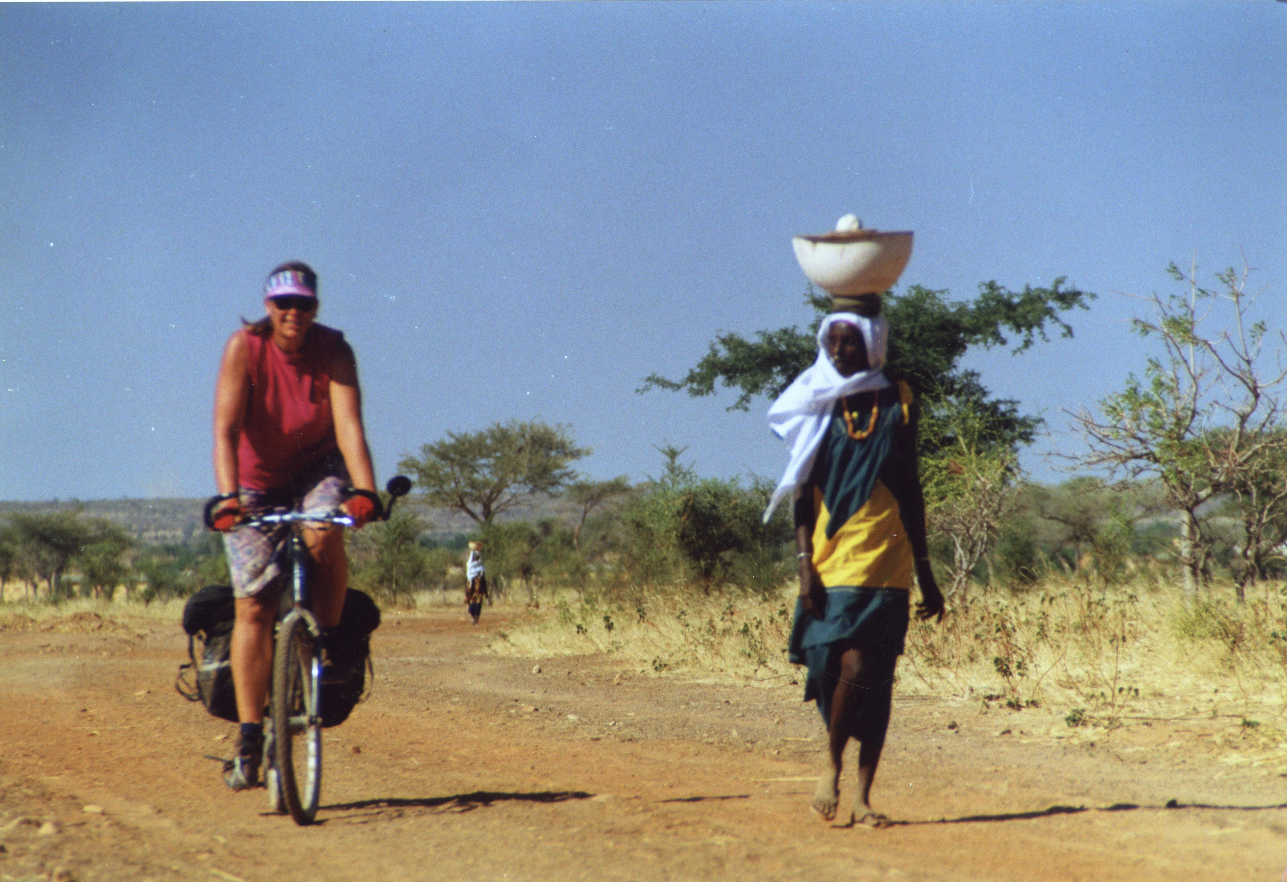 Nancy Explains: "Me cycling in Mali. We had the brilliant idea of taking off across a dirt road the map showed cutting through the desert. As we progressed farther, the road condition deteriorated and eventually the road turned into nothing more than a small trail. People assured us that Djenne was "that way" so we kept going - for about 80 miles along the little trail going through the desert. We were thrilled when we finally emerged from the desert!"