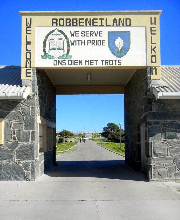 Ready to enter Robben Island Prison – where Nelson Mandela spent 18 years (The motto over the gate (We Serve With Pride) is just too weird!)