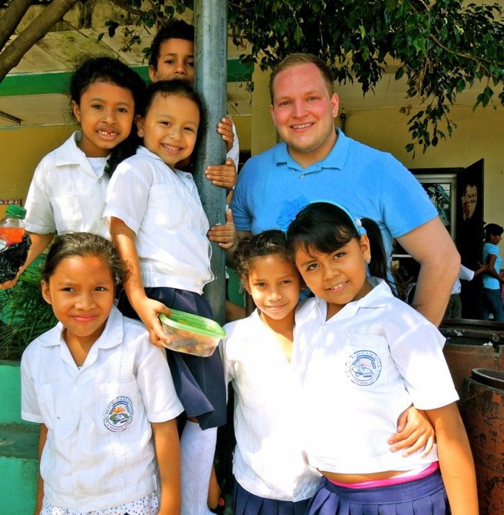 Matt in Honduras, taking a break from painting to spend time with some students.