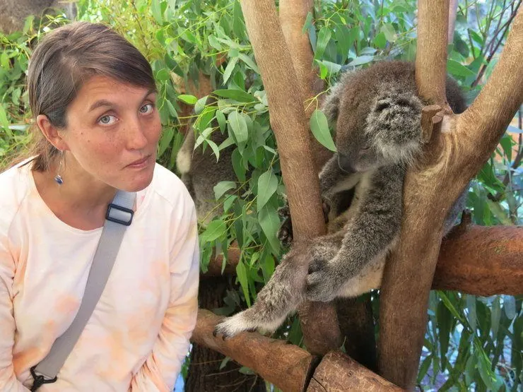 Tasha with a koala in Australia with the look of someone who is disappointed the koalas aren’t awake.