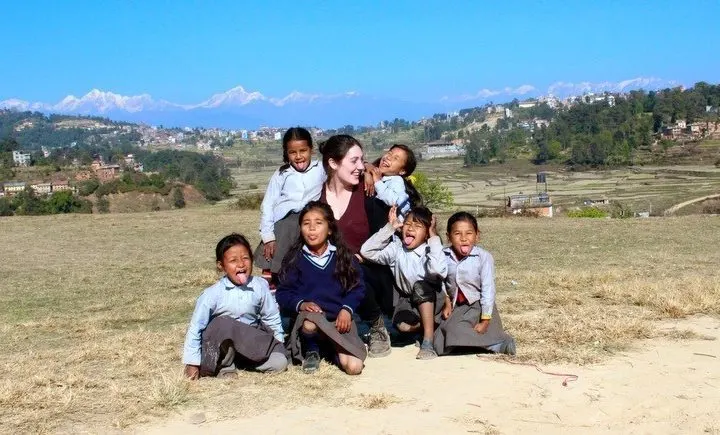 Beth and a group of students in front of the Himalayas.