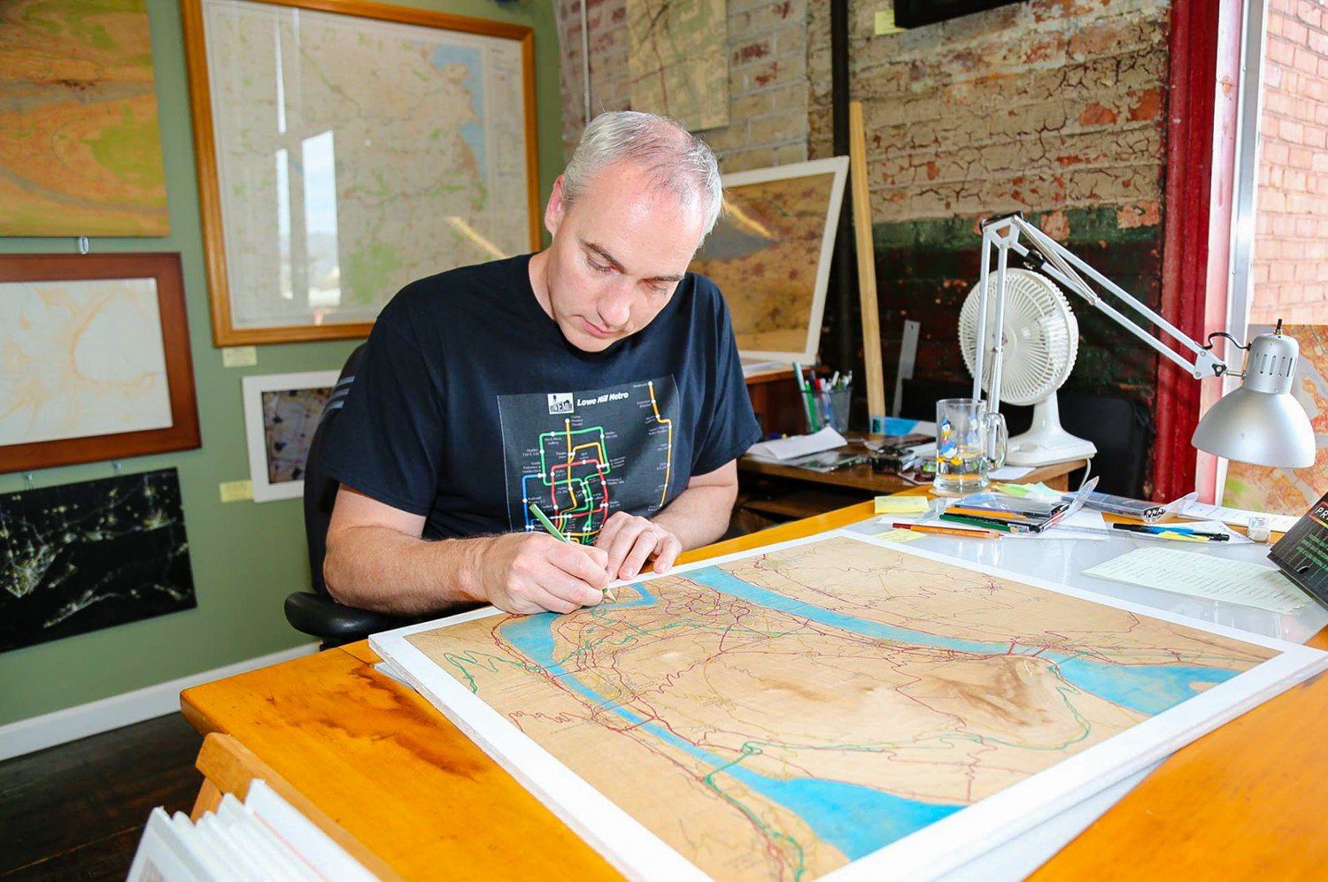 David in his studio, working on one of his maps.