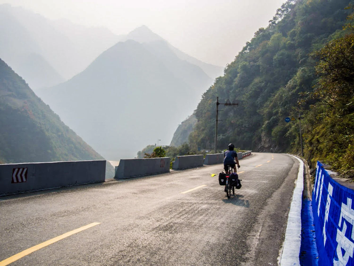Stephen ascending a misty mountain pass by bike in China.