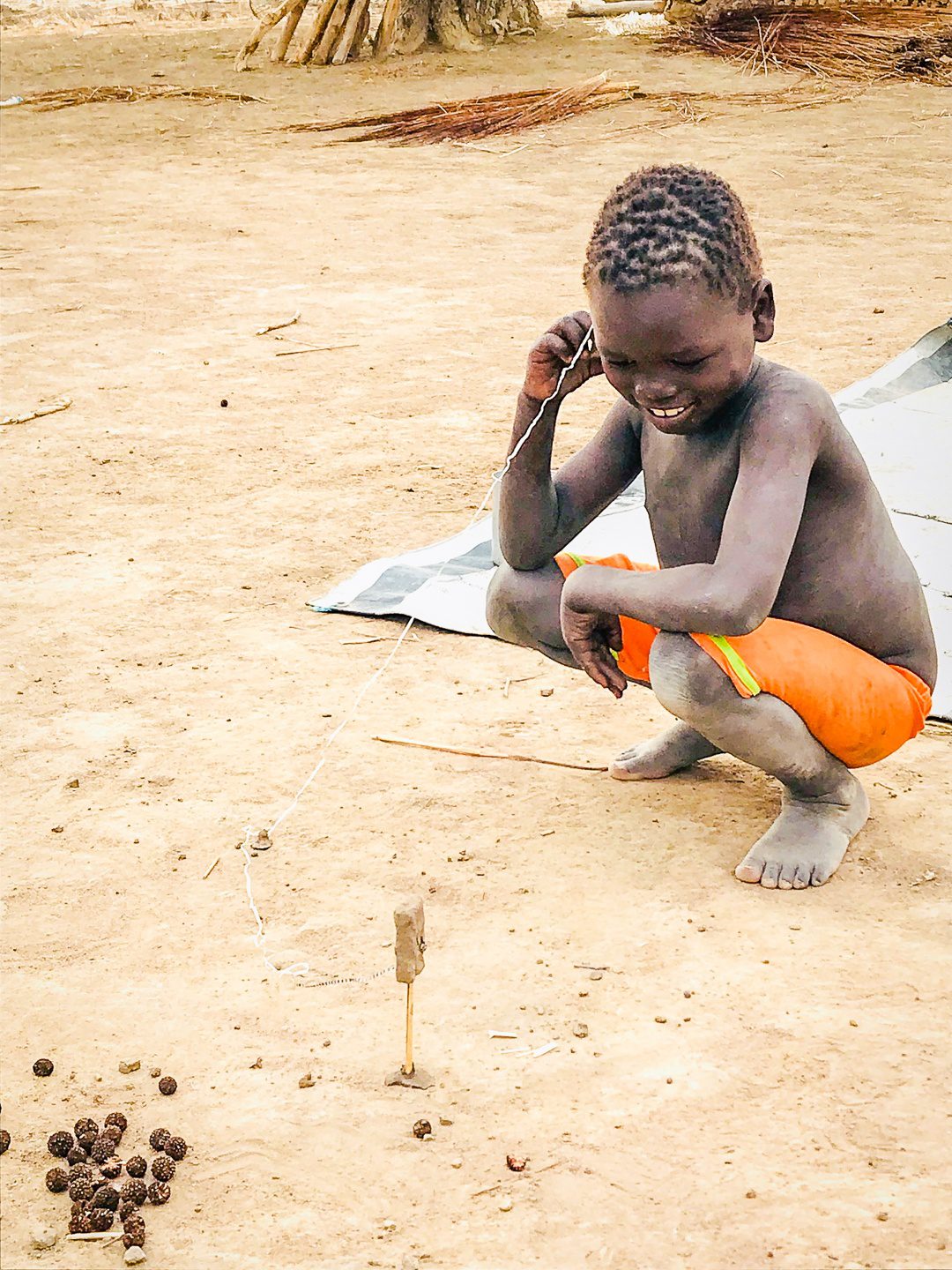 A boy in South Sudan making his own toy.