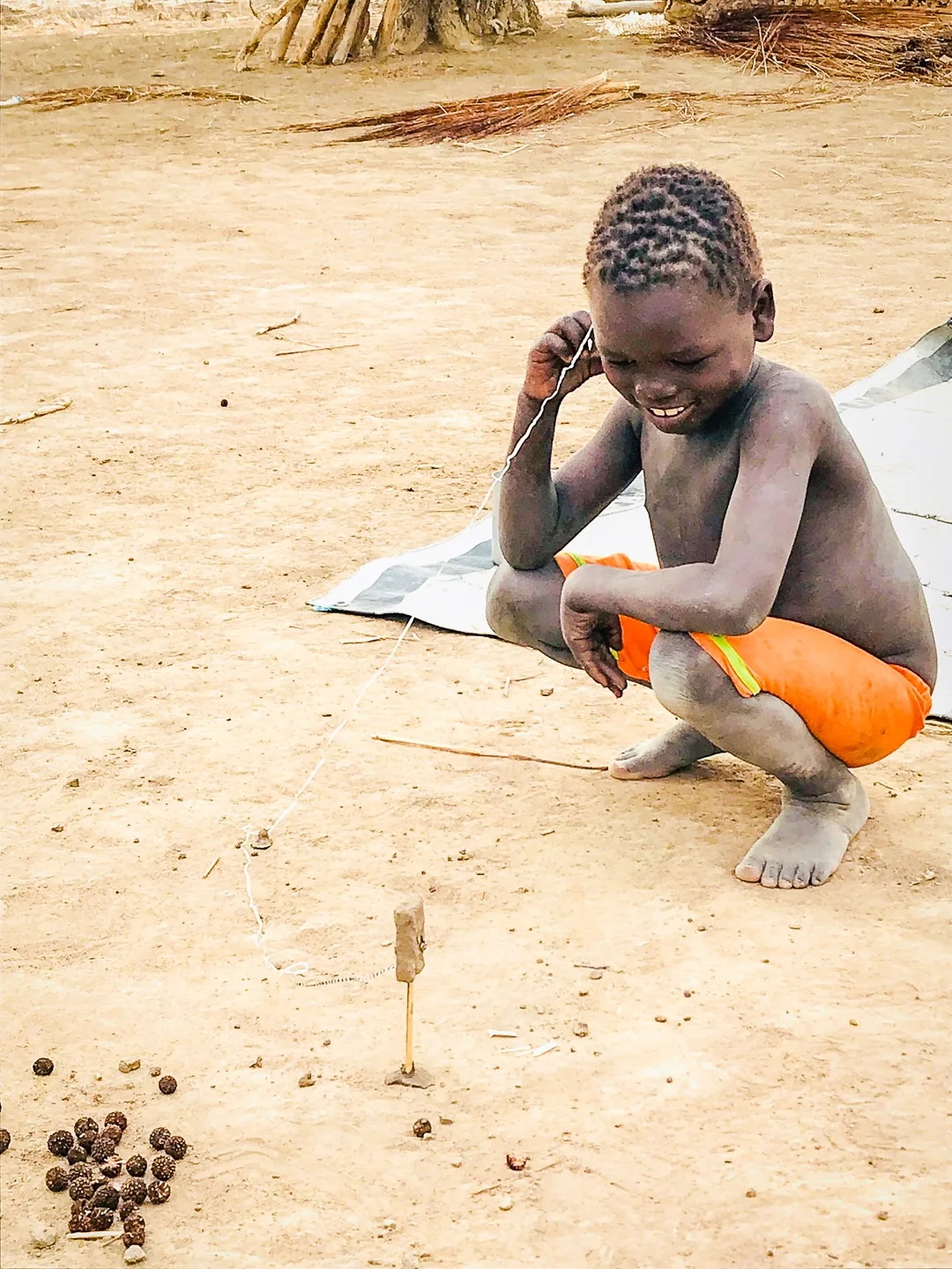 A boy in South Sudan making his own toy.