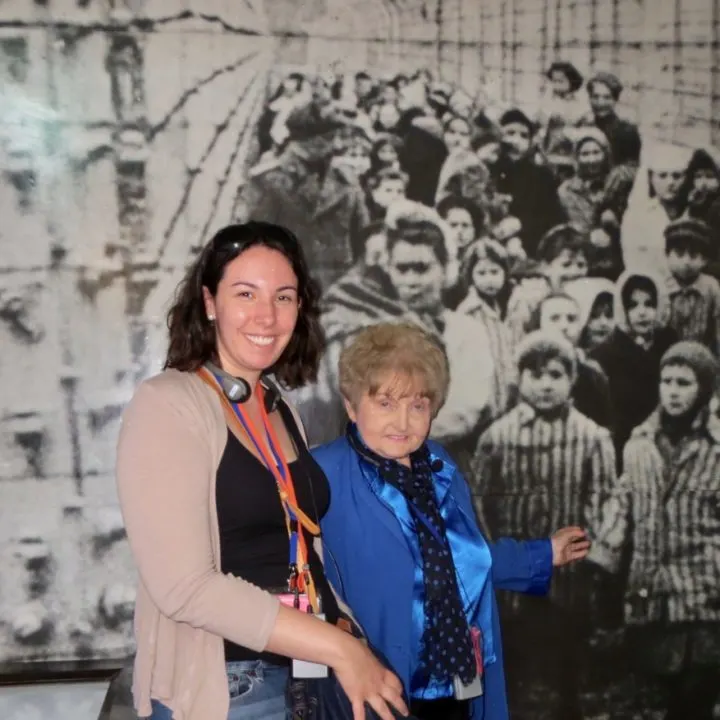 With Eva Kor in front of a liberation photo. The child she is pointing to is herself! The little girl next to her was her twin sister, Miriam.