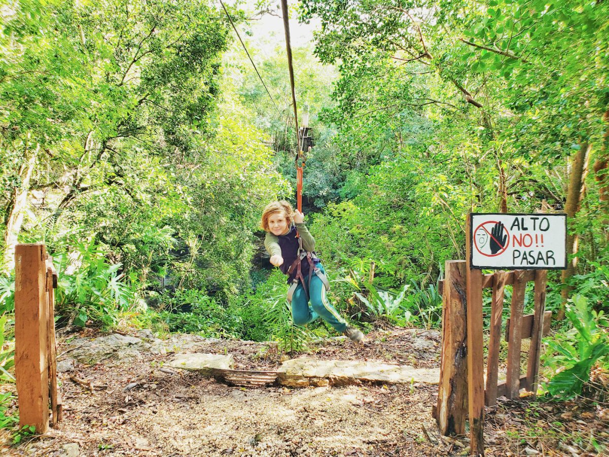 Cassie son ziplining over cenote